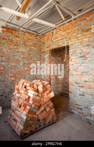 Beginn des Baus einer neuen Wohnung mit Backsteinwänden im neuen Apartmentgebäude. Stockfoto