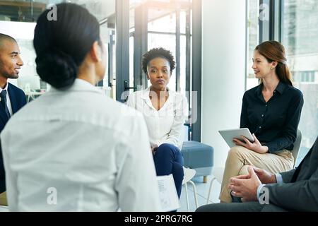 Was macht Sie der ideale Kandidat für diese Position. Eine Gruppe von Geschäftsleuten Interviews mit einem potenziellen Mitarbeiter in der Vorstandsetage. Stockfoto