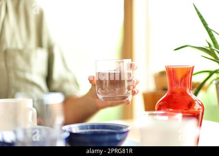 Eine Frau, die in einem Restaurant Wasserglas hält Stockfoto