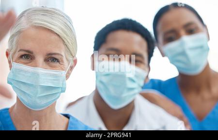 Selfie des Teams von Ärzten mit Maske für Sicherheit gegen Covid, Corona Pandemie, oder Virus in einem Krankenhaus. Portrait von Mitarbeitern im Gesundheitswesen oder medizinischen Fachkräften gemeinsam für Unterstützung, Teamarbeit und Zusammenarbeit Stockfoto