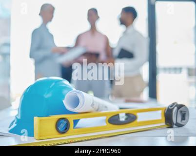 Ausrüstung oder Architekturtools in einem Büro von Ingenieuren, die während einer Besprechung in einem Vorstandssaal planen. Zeichnen oder Bauprojekt auf einem Schreibtisch oder Tisch für die Baukonstruktion Stockfoto