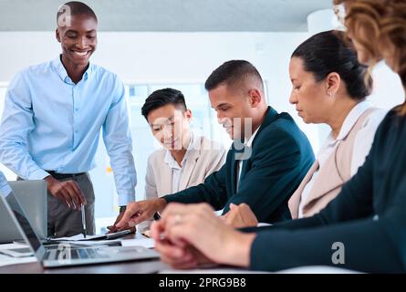 Zufriedene Geschäftsleute starten die E-Commerce-Website auf einem Laptop mit dem ux- oder ui-Team, Grafikdesigner und Marketing-Manager. Diversity-Mitarbeiter in einem Geschäftstreffen freuen sich auf die Entwicklung digitaler Unternehmensanwendungen Stockfoto