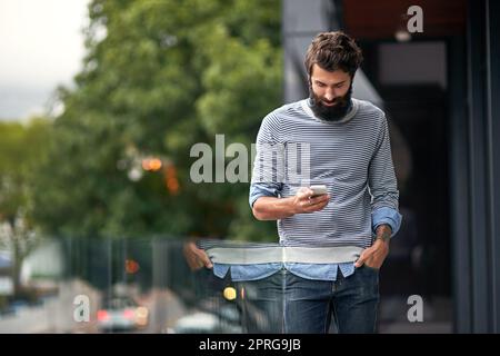 Treffen wir uns nach der Arbeit. Eine junge kreative SMS auf einem Handy draußen. Stockfoto