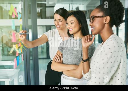 Ich habe eine Idee. Drei Geschäftsfrau, die in ihrem Büro strategisch antritt. Stockfoto