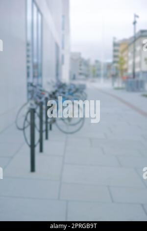 Bereit zum Fahren. Verschwommene Aufnahme eines Fahrrads an einem Fahrradständer in einer Stadt. Stockfoto