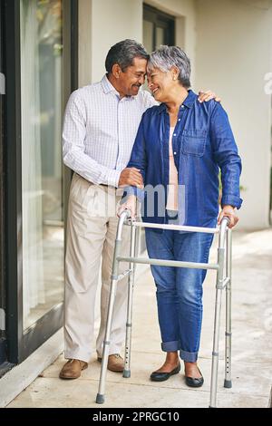 Nun, immer für einander da sein. Ein älterer Mann geht mit seiner Frau und ihrem Spaziergänger draußen spazieren. Stockfoto