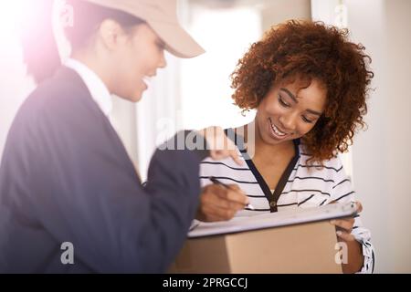 Ich brauche nur, dass Ihr dort hinüberschreibt. Aufnahme eines Kuriers, der eine Lieferung an einen lächelnden Kunden abgibt. Stockfoto