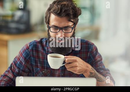 Sammeln von Daten über das Kundenverhalten und die Bedürfnisse des Marktes. Ein Designer, der Kaffee getrunken hat, während er an seinem Laptop arbeitete. Stockfoto