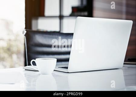 Mit den richtigen Tools von lokal auf global umsteigen. Nahaufnahme eines Laptops und einer Kaffeetasse auf einem Schreibtisch. Stockfoto