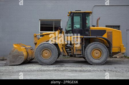 Traktorlader auf der Baustelle, gelbe HD-Hydraulikausrüstung Stockfoto