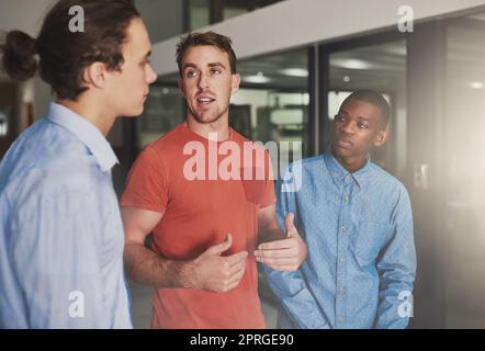 Planung des neuesten Projekts. Drei Kollegen diskutieren im Büro. Stockfoto