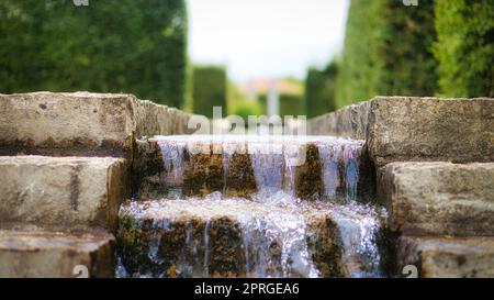 Wasserfall über einer Steintreppe. Ein Bach, der durch einen Park fließt. Stockfoto