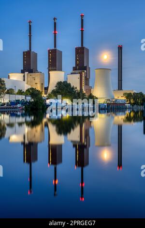 Ein Thermalkraftwerk in Berlin spiegelte sich in der Dämmerung in einem Kanal wider Stockfoto