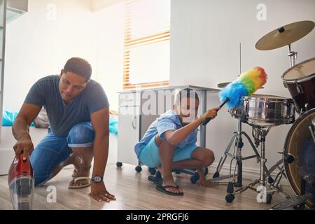 Alles ordentlich halten. Porträt eines Vaters und eines Sohnes, der um das Haus putzt. Stockfoto