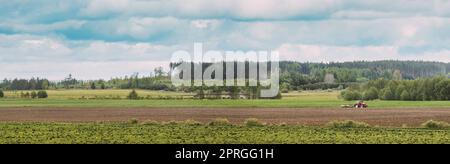 Pflügen Von Traktoren In Der Frühlingssaison. Beginn Der Landwirtschaftlichen Frühjahrssaison. Kultivator, der von Einem Traktor auf dem Land gezogen wird. Landschaftsbild Ländlicher Felder. Panorama Stockfoto