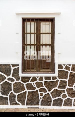 Alte hölzerne Fensterläden und Gitter an den Fenstern. Hintergrund. Stockfoto