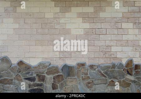 Urigen alten beige weiße Mauer Hintergrund schäbig und abgenutzt, die Stiftung mit braunen Steinen Stockfoto