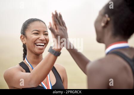 Ich bin so stolz, mit dir zu laufen. Zwei Athleten, die sich gegenseitig High Fiving Stockfoto