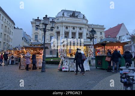 Touristen, die auf den Souvenir- und Kunsthandwerksständen vor dem slowakischen Nationaltheater in Bratislava, Slowakei, stöbern Stockfoto