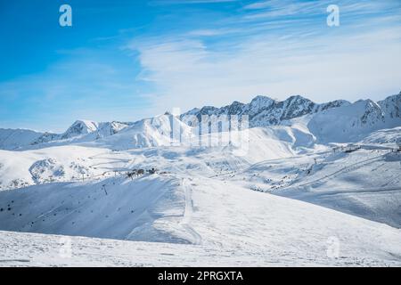 Skilifte, Skifahrer und Snowboarder auf Pisten in schöner Winterlandschaft mit Bergkette im Hintergrund, Andorra, El Tarter, Pyrenäen Stockfoto