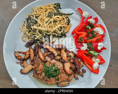 Teller, gebratener roter Thunfisch mit Shiitake-Pilzen und Spaghetti mit Kapern und Spinatblättern Stockfoto