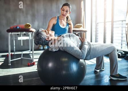 Bewegung ist der Schlüssel zu einem gesunden Geist, Herz und Körper. Eine ältere Frau arbeitet mit ihrem Physiotherapeuten. Stockfoto