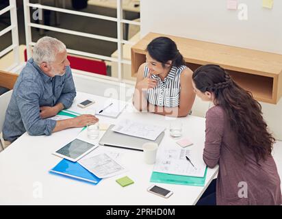 Die Kombination aus ihren Fähigkeiten. Ein Team von Kollegen, die in einem modernen Büro ein Meeting abhalten. Stockfoto