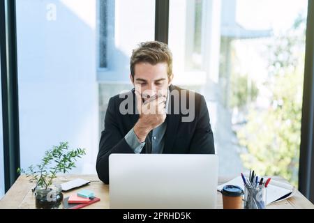 Gewidmet dem Job. Ein hübscher junger Geschäftsmann im Büro. Stockfoto