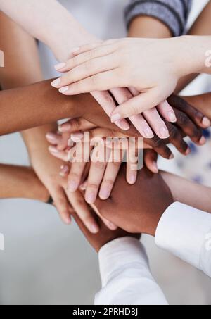 Teamwork stärkt alle. Eine Gruppe von Menschen, die ihre Hände zusammenlegen. Stockfoto