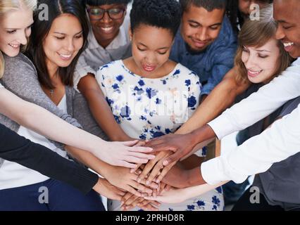 Zeigt einen unterstützenden Geist. Eine Gruppe von Menschen, die ihre Hände zusammenlegen. Stockfoto