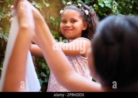 Im Mummys bester Helfer. Porträt eines jungen Mädchens, das mit ihrer Mutter Wäsche an einer Wäscheleine aufhängt. Stockfoto