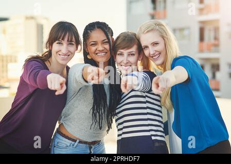 Besuchen Sie uns noch heute. Porträt einer Gruppe von Frauen, die mit den Fingern auf die Kamera zeigen. Stockfoto