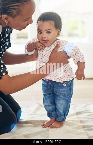 Shes wächst so schnell auf. Porträt eines lächelnden Mädchens, das mit der Unterstützung ihrer Mutter steht. Stockfoto