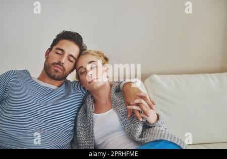 Nichts Besseres als ein Mittagsschlaf am Sonntag. Junges Paar, das zu Hause ein Nickerchen auf dem Sofa macht. Stockfoto