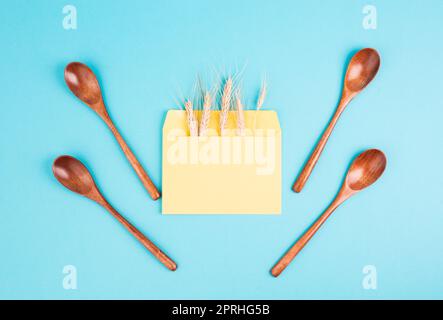 Umschlag mit Weizenohren und leeren Löffeln, Lebensmittelknappheit und steigenden Preisen, Armut durch Inflation Stockfoto