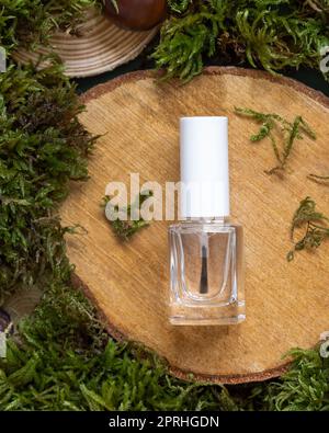 Nachfüllbare Flasche mit Bürstenverschluss auf Holzstück zwischen grünem Moos, Nagelmodell Stockfoto