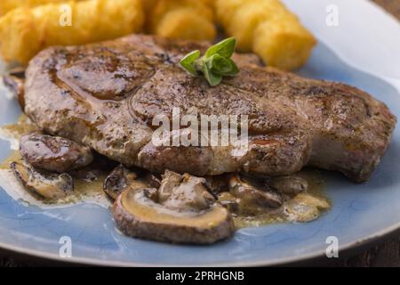 Schweinesteak mit Pilzsauce Stockfoto