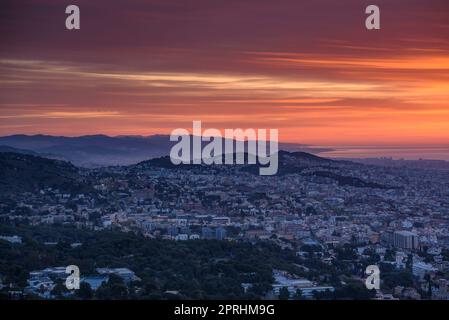 Rötlicher Sonnenaufgang über der Stadt Barcelona vom Gipfel des Sant Pere Màrtir in Collserola (Barcelona, Katalonien, Spanien) Stockfoto