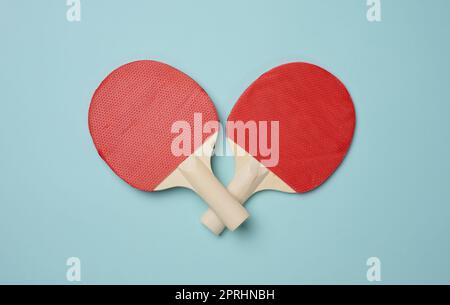 Ein Paar Tennisschläger aus Holz für Tischtennis auf blauem Hintergrund, Draufsicht Stockfoto