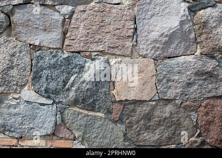 Steinmauer mit verschiedenen Farben und Größe der Felsen Stockfoto