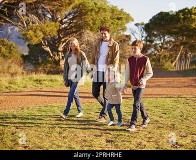 Auf einem gemütlichen Familienspaziergang. Eine junge Familie genießt einen Spaziergang im Freien Stockfoto