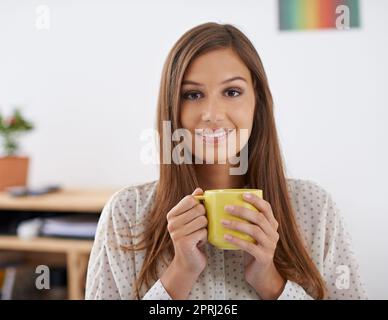 Ich liebe den Geruch der Möglichkeit am Morgen. Porträt einer schönen jungen Frau, die eine Tasse Kaffee in der Hand hält Stockfoto