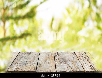 Leere Holzplanke mit unscharfer grüner Natur hinterlässt Hintergrundlicht für Bokeh Stockfoto