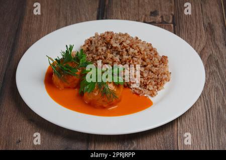 Buchweizengrütze und Frikadellen auf Holztisch Stockfoto