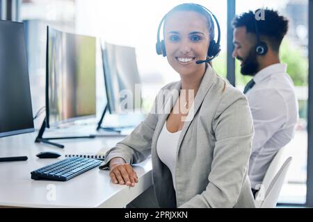 Mitarbeiter, Frau und Porträt lächeln am Schreibtisch im Büro des Kundendienstberatungsunternehmens. Zufriedene, professionelle und positive Mitarbeiterin in der Telemarketing-Karriere, die mit ihrer Berufswahl zufrieden ist. Stockfoto