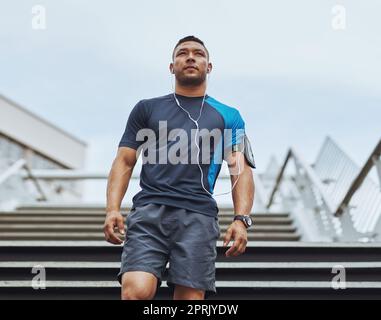 So bereit dafür. Low-Angle-Aufnahme eines männlichen Läufers, der auf einer Treppe in der Stadt steht. Stockfoto