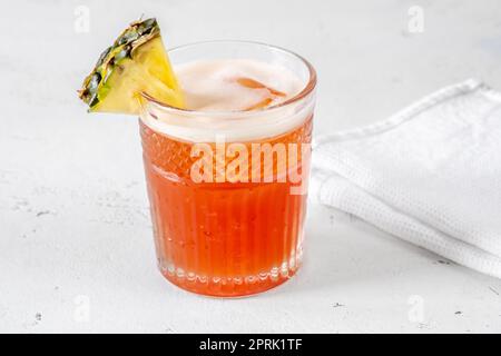 Ein Glas Jungle Bird Cocktail garniert mit Ananaskeil Stockfoto