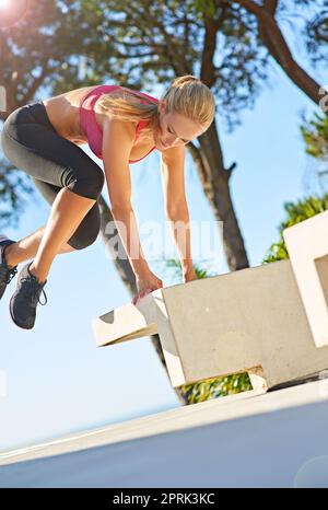 Sie trainiert wahnsinnig. Ganzkörperaufnahme einer jungen Frau, die im Freien trainiert. Stockfoto