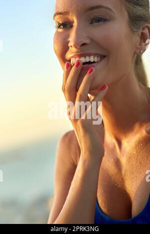 Positive Gefühle über ihr Workout. Eine sportliche junge Frau, die draußen steht. Stockfoto