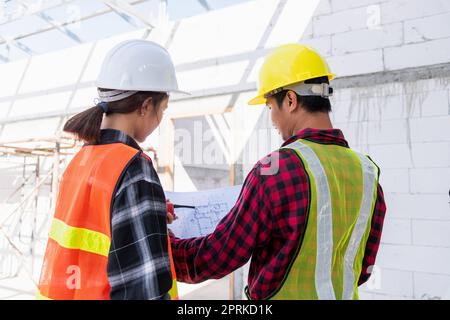 Architekt und Bauherr besprechen den Plan mit dem Bauplan des Gebäudes auf der Baustelle. Asiatische Ingenieur Vorarbeiter Arbeiter Mann und Frau arbeiten Gespräch Stockfoto
